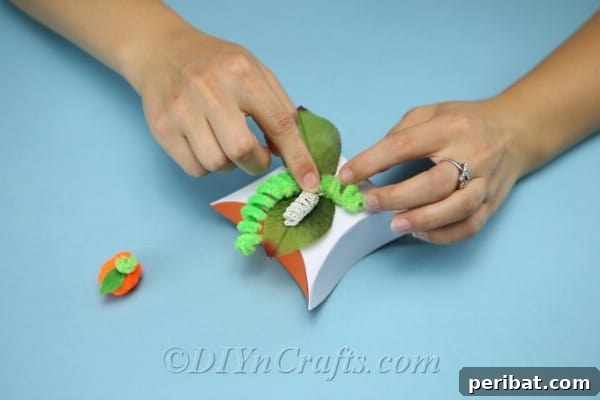 Craft Charming Pumpkin Gift Boxes 15 Gluing curly green pipe cleaners to the top of the DIY gift box, resembling pumpkin vines