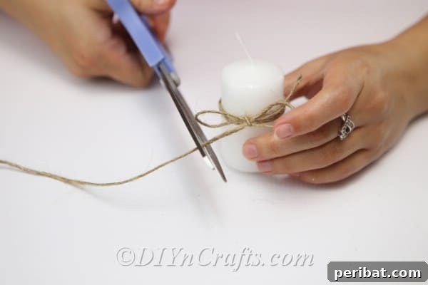 Rustic Glow: DIY Wine Glass Candle Holder 16 Trimming the ends of the twine after securing the bow around the candle for a neat finish.