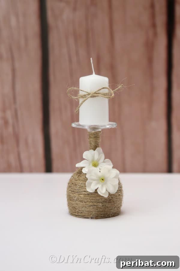 Rustic Glow: DIY Wine Glass Candle Holder 18 The rustic candle holder positioned outdoors on a wooden surface with a charming fence in the background, showcasing its versatility.