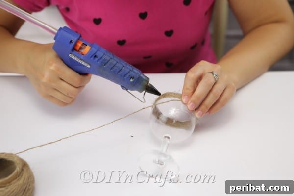 Rustic Glow: DIY Wine Glass Candle Holder 7 Carefully wrapping twine around the bowl of the wine glass, moving downwards from the rim.