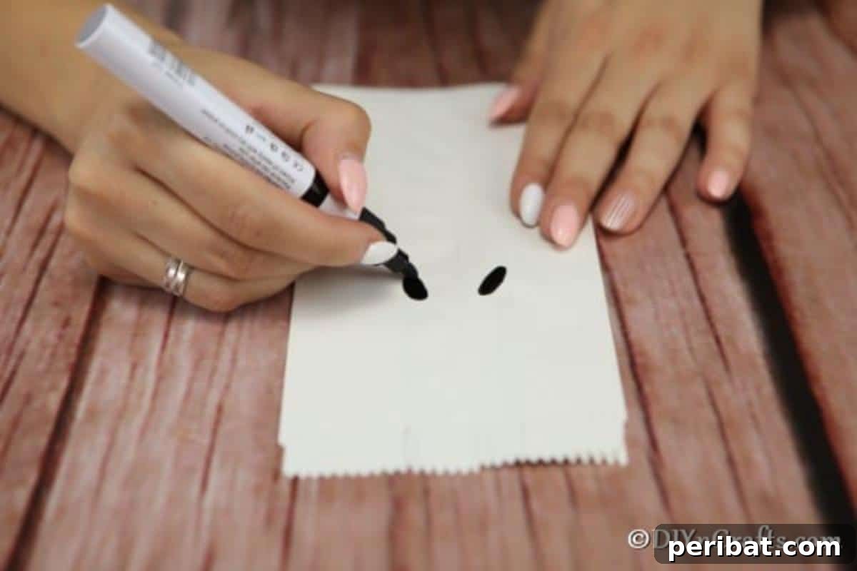 DIY Ghostly Glow Bags for Halloween 6 Creating a spooky or funny ghost face on a luminary bag for Halloween using a black marker