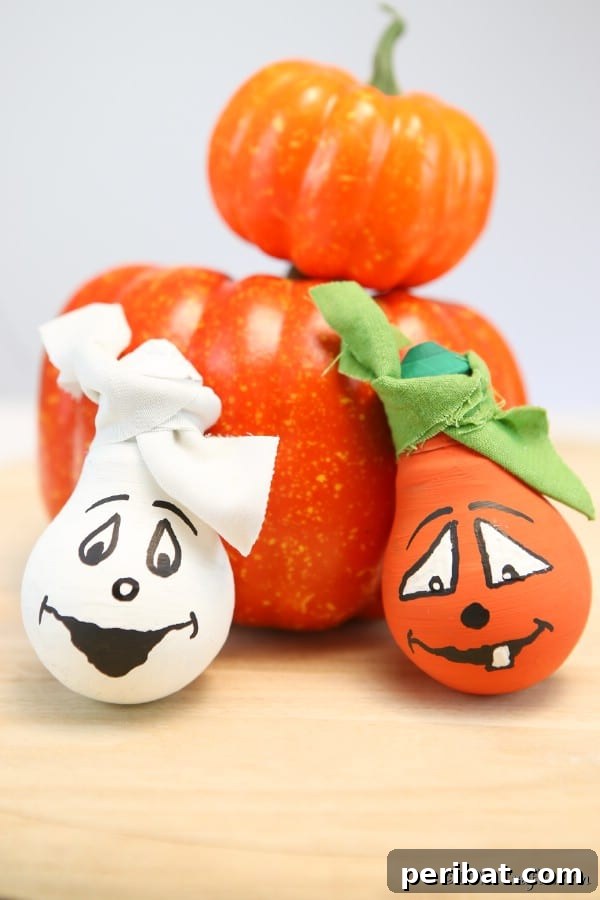 Decorative light bulbs for Halloween sitting on a counter leaned against pumpkins