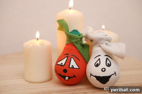 Crafting Spooky Ghosts and Pumpkins from Light Bulbs 19 Decorative Halloween light bulbs leaned against candles sitting on a wooden table