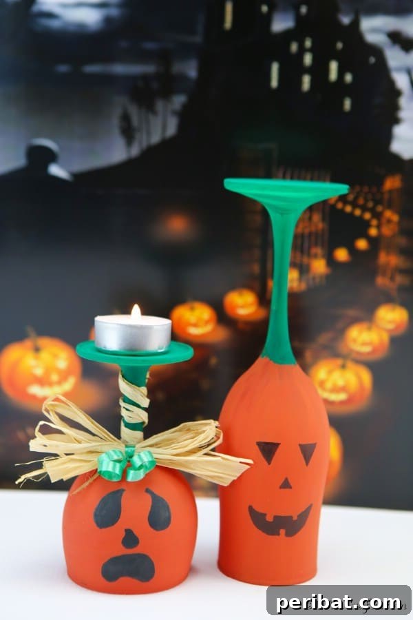 Finished wine glass pumpkin art sitting on a white surface with a black halloween themed background