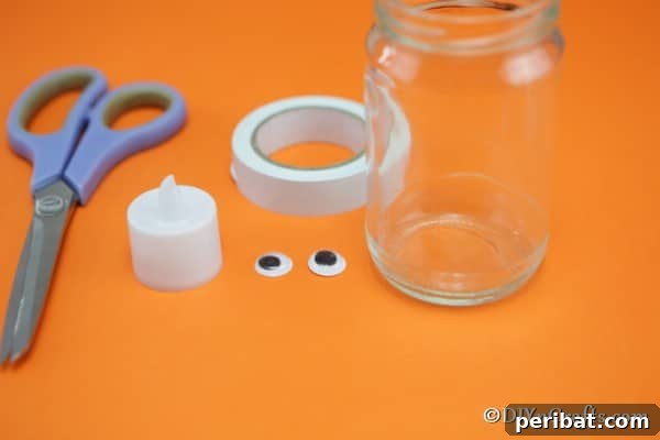 A flat lay showing all materials: jar, tape, googly eyes, scissors, and glue gun, laid out neatly.