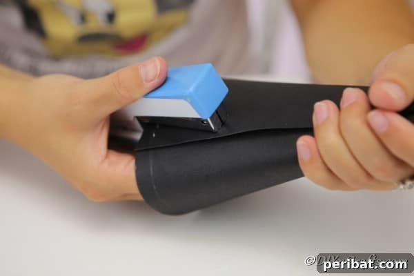 Bewitching DIY Witch Hat for Halloween 14 Stapling the cardboard together for the witch hat
