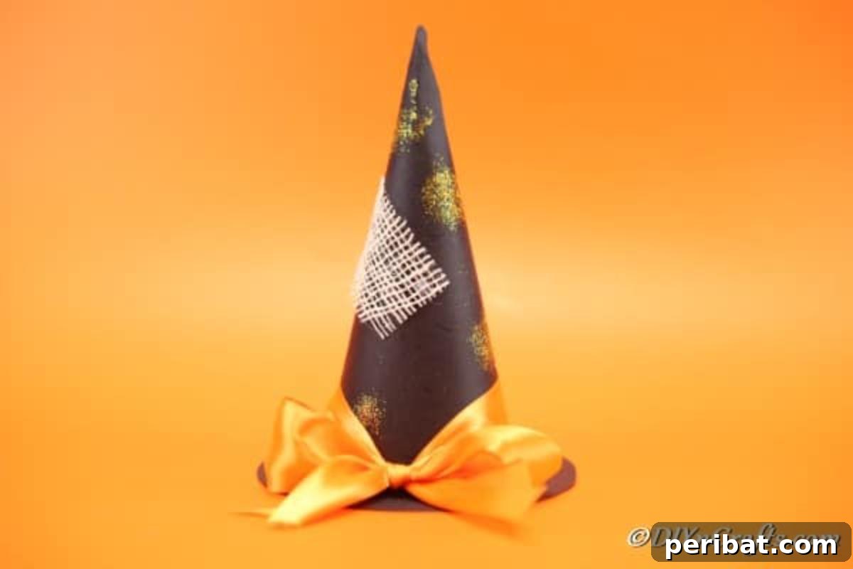 Bewitching DIY Witch Hat for Halloween 5 A beautifully finished DIY witch hat Halloween decoration, ready for display with orange ribbon and glitter