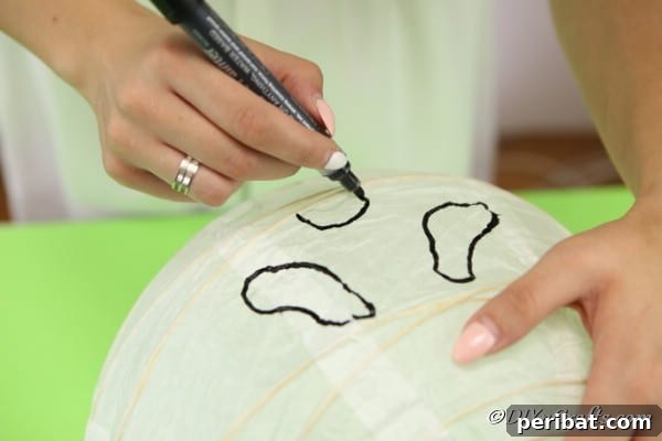 Hauntingly Simple Ghost Lanterns 10 Drawing a face on the ghost paper lanterns with a marker