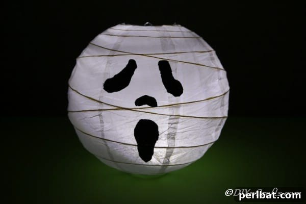 Hauntingly Simple Ghost Lanterns 15 A completed ghost paper lanterns project in a dark room with soft glow