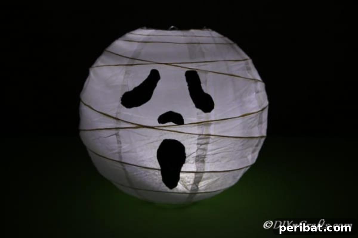 Hauntingly Simple Ghost Lanterns 3 Ghost paper lanterns sitting in a dark room with candle light glow