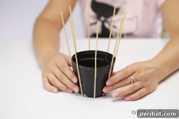 Craft a Charming Rustic Basket 13 Gluing the dowels onto the flower pot with hot glue for the woven basket