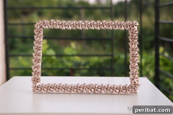 A completed pasta picture frame on a table outside