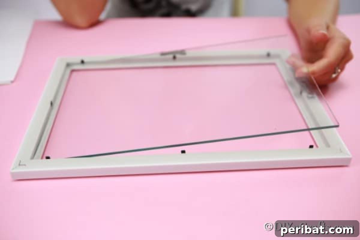 Taking the glass out of a picture frame for macaroni art