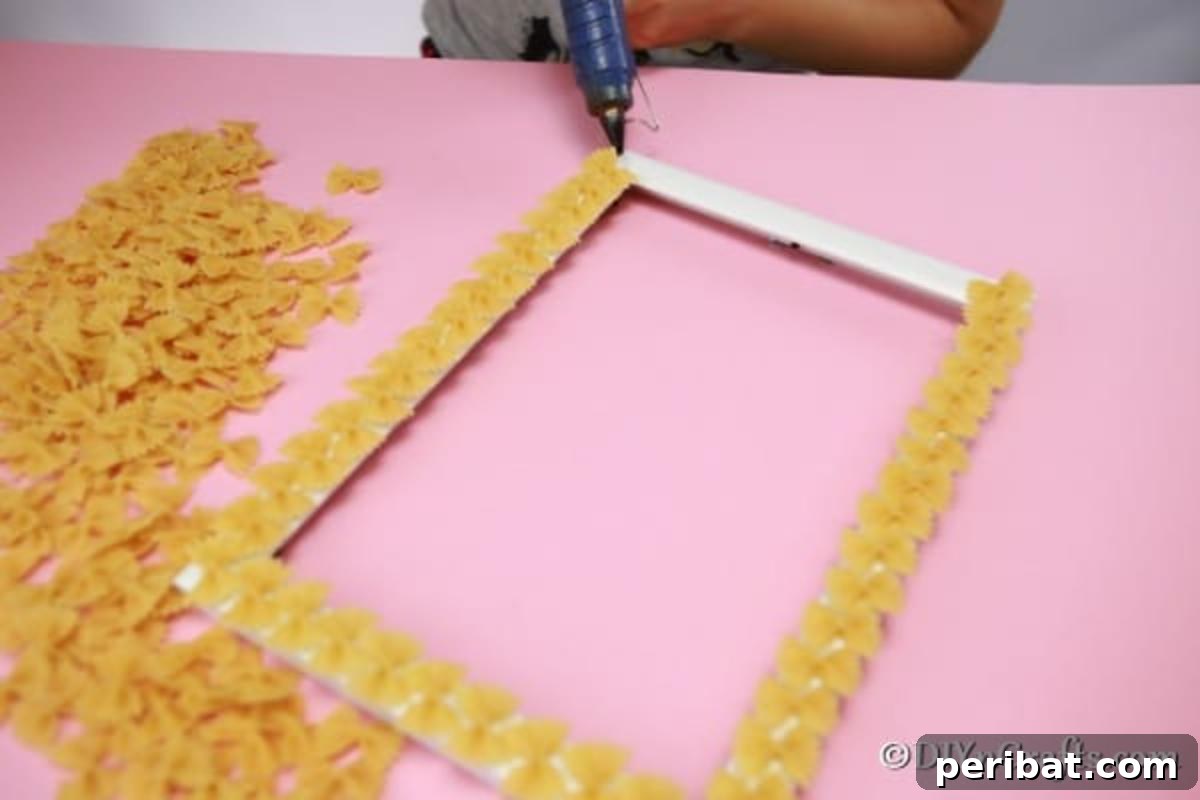 Adding pasta to a picture frame with hot glue