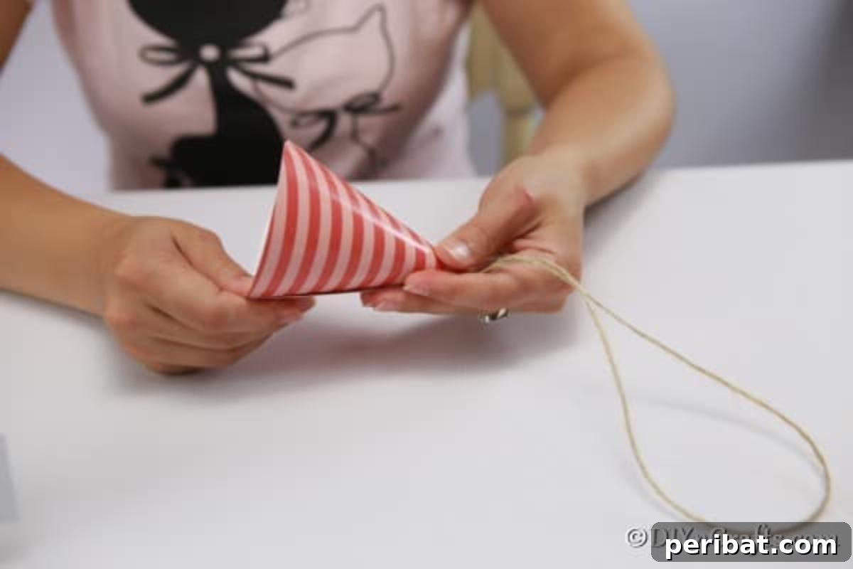 Enchanting Paper Gnome Homes for Your Garden 9 Shaping the cone top of a fairy house out of paper, showing the rolling process