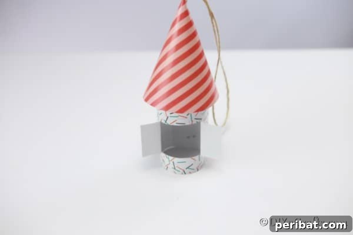 Enchanting Paper Gnome Homes for Your Garden 10 A completed gnome house on a white counter with a hanging thread, ready for display