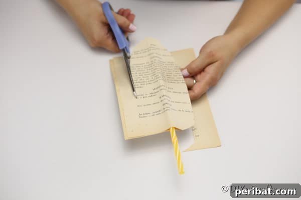 Cutting the feather shape out of old book pages
