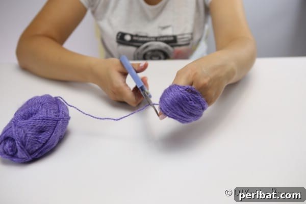 Wrapping yarn around a palm to create a pom pom flower