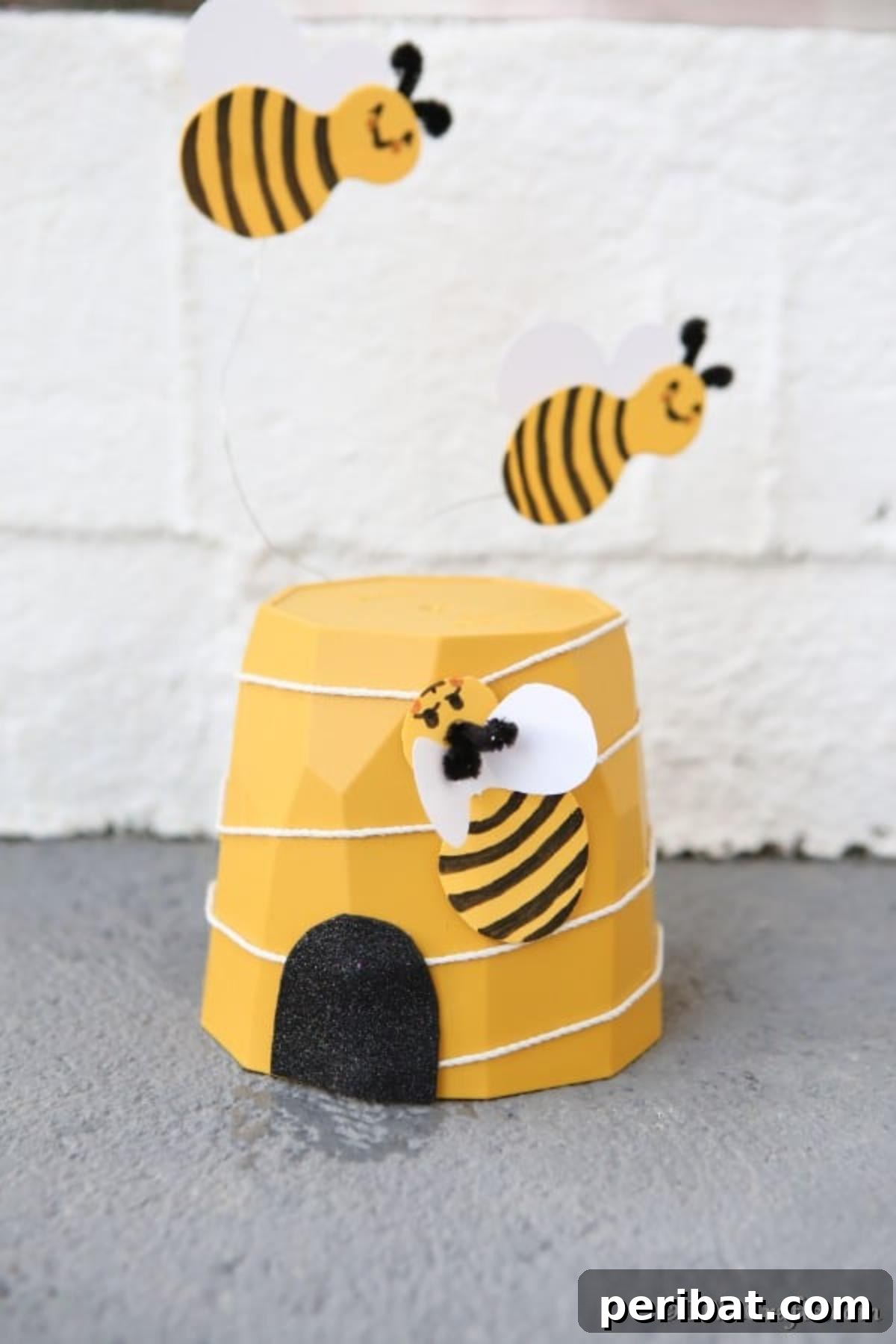 Whimsical Bee Garden Planter 11 A flower pot bee decoration sitting against a concrete wall
