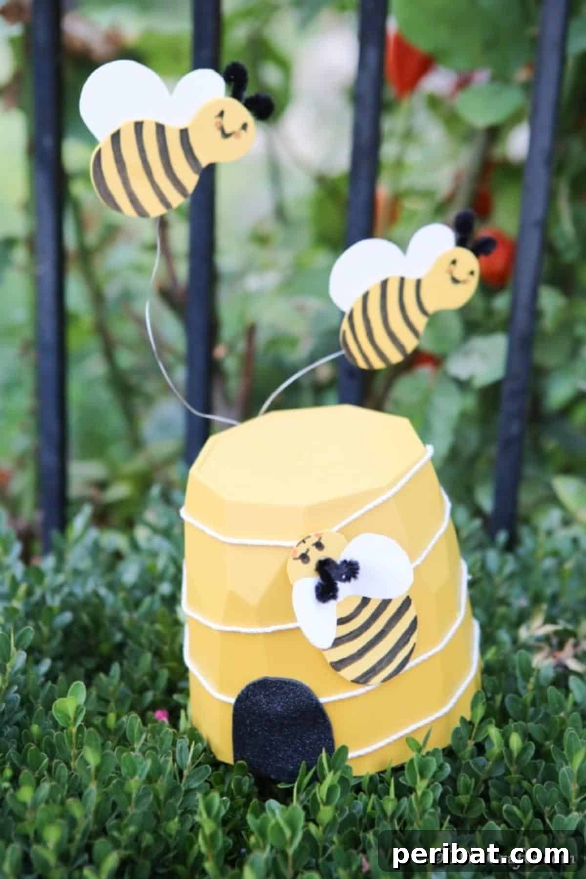 Whimsical Bee Garden Planter 4 A yellow flower pot bee garden decoration on the edge of a shrub