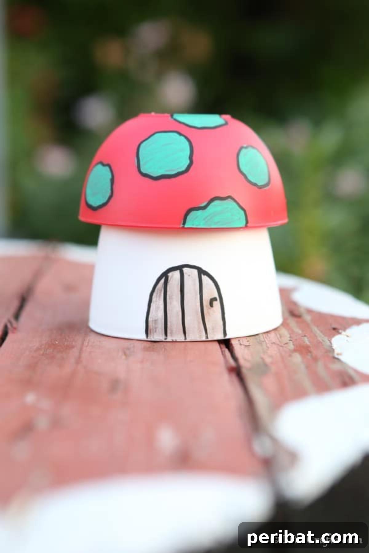 Whimsical Hand-Painted Mushroom Garden Planter 4 A beautifully painted mushroom planter garden decoration sits on a rustic picnic table