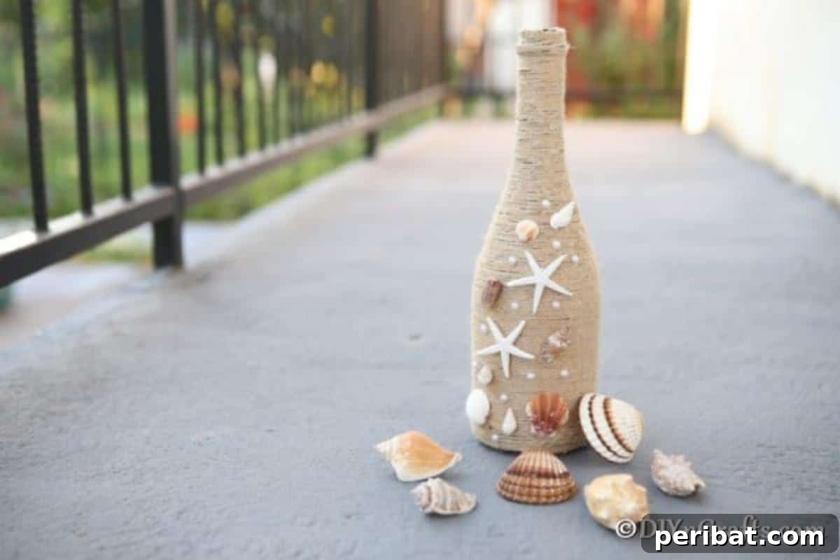 Coastal Rustic Wine Bottle Charm 3 Elegant rustic wine bottle decor with twine and shells, showcased on a concrete surface, highlighting its natural beauty.