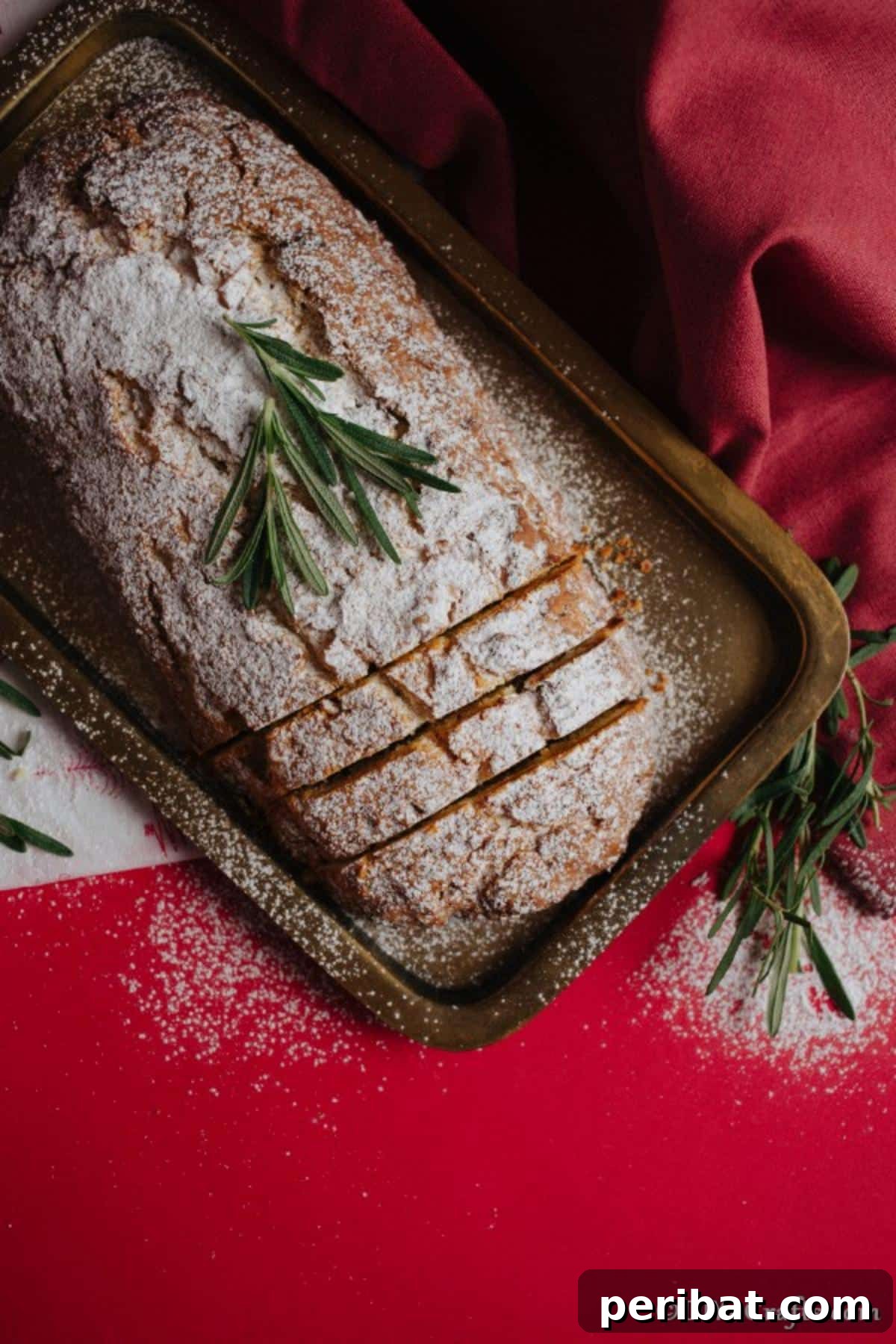 German Christmas Stollen Festive Bread Recipe 9 An overhead shot of a baked Christmas Stollen, freshly dusted with powdered sugar, resting on a baking sheet
