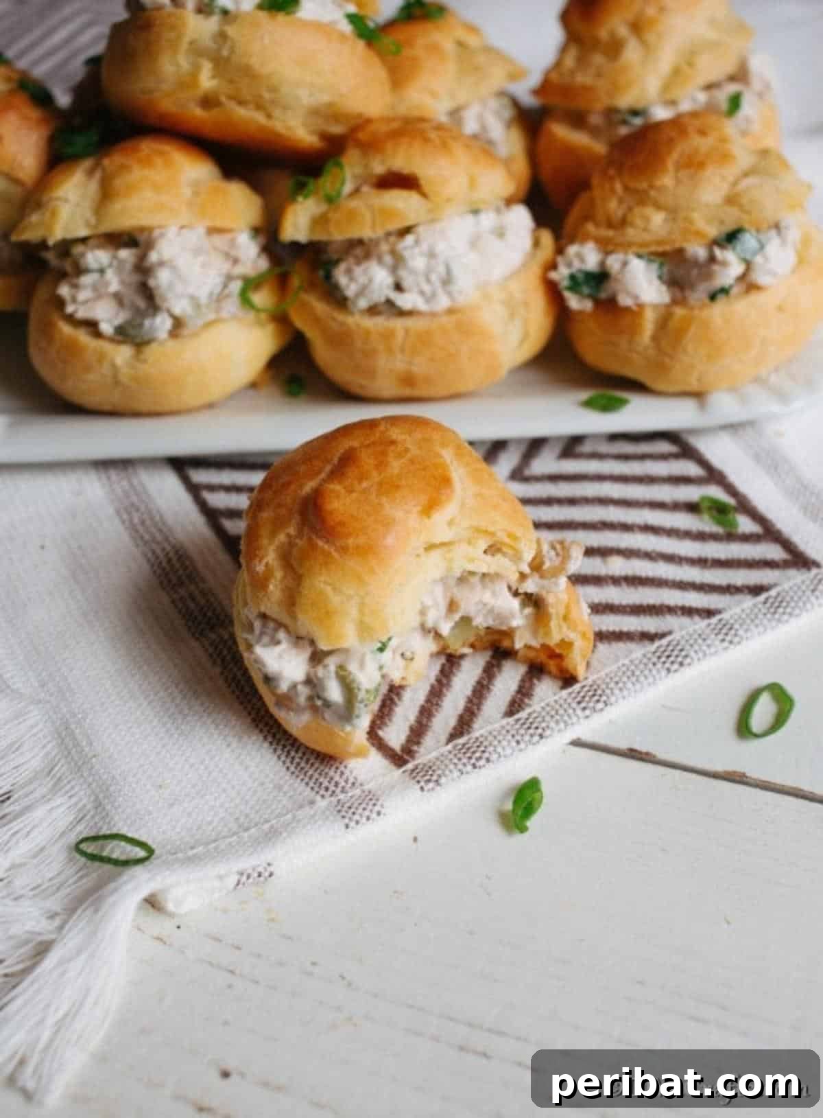 Golden Puffs, Creamy Chicken Salad 4 A homemade chicken salad puff pastry sandwich with a bite out of it