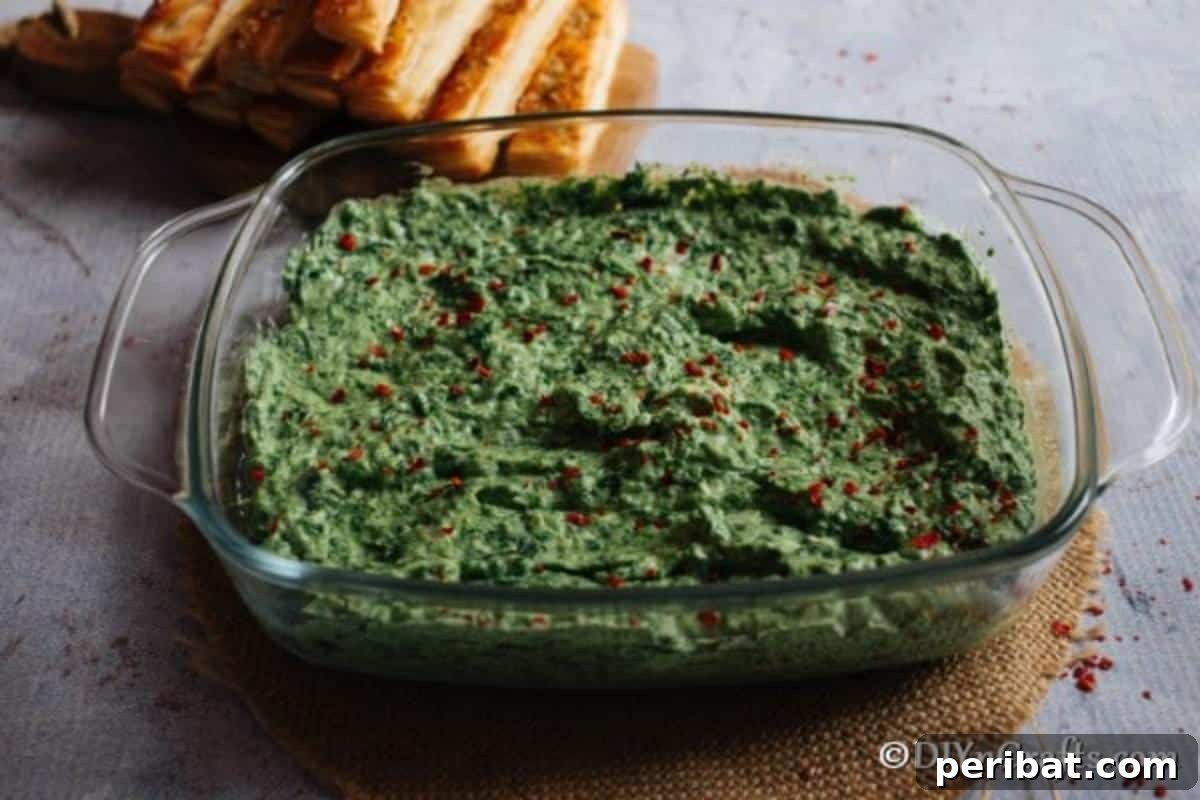 A large glass dish filled with hot spinach dip