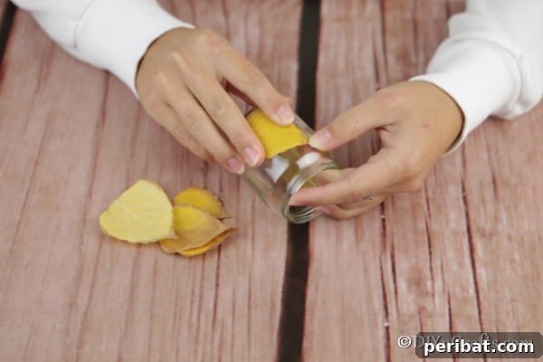 Attaching leaf to a candle lantern craft, showing the final steps of securing leaves