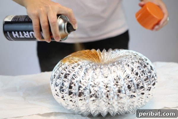 Easy DIY Dryer Vent Pumpkins Video Tutorial Included 14 Spray painting the dryer vent with orange paint for pumpkin decor