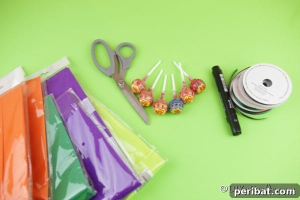 Supplies for making ghost lollipops on a green surface
