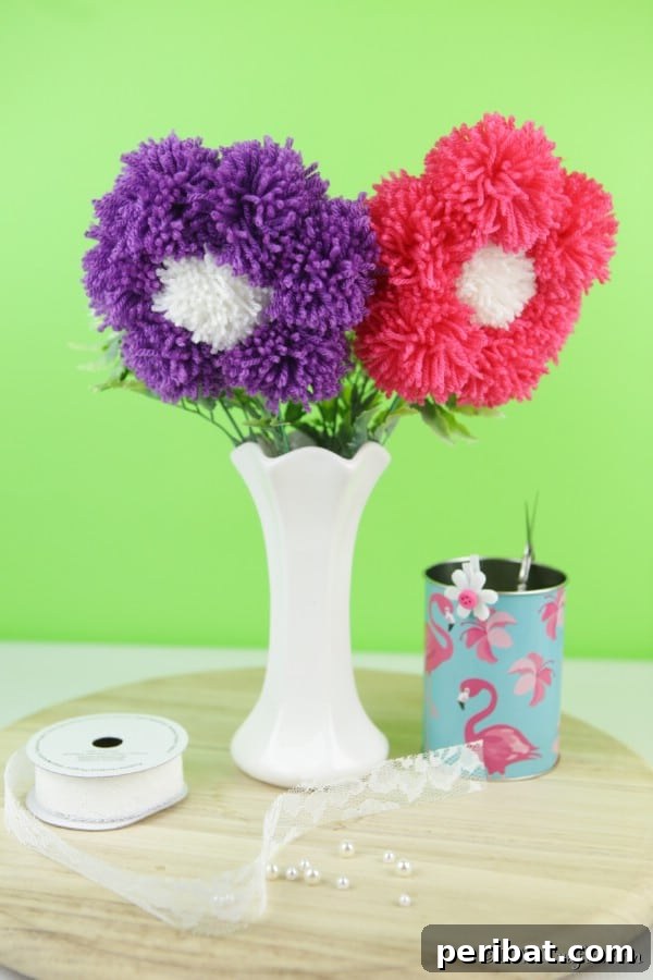 Yarn Pom-Pom Floral Displays 22 A white vase with yarn pom poms flowers and a green background
