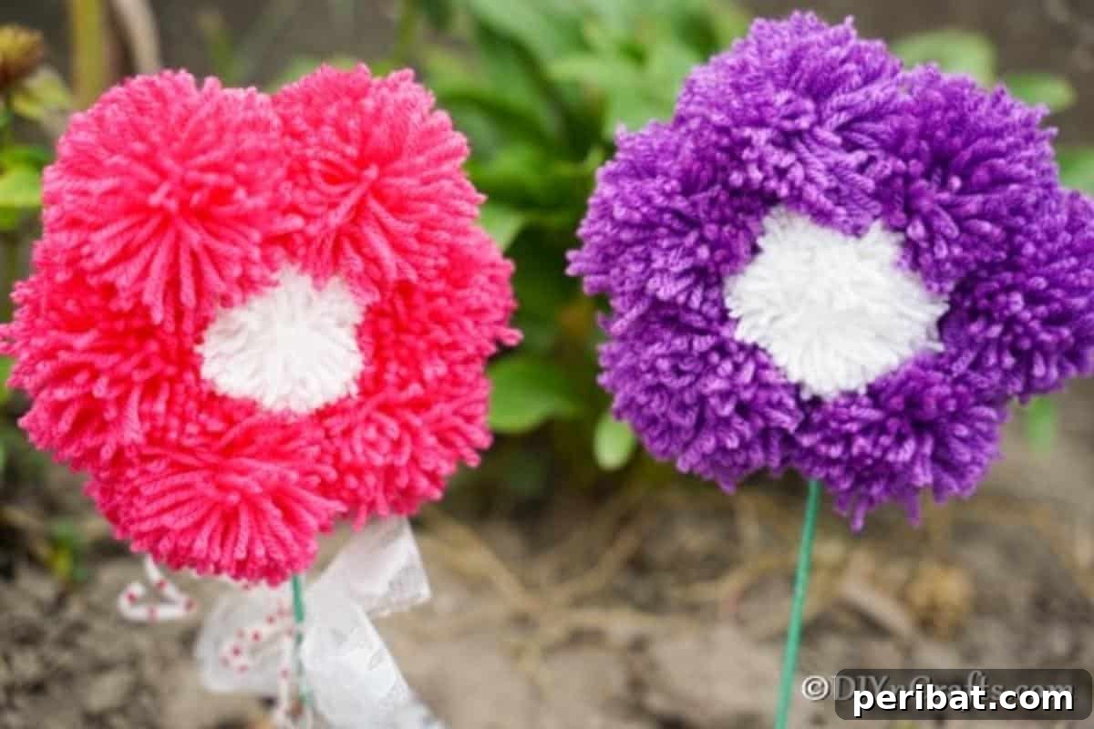 Yarn Pom-Pom Floral Displays 5 Cheerful pink and purple yarn pom pom flowers displayed outdoors, showcasing their vibrant colors and fluffy texture in natural light.