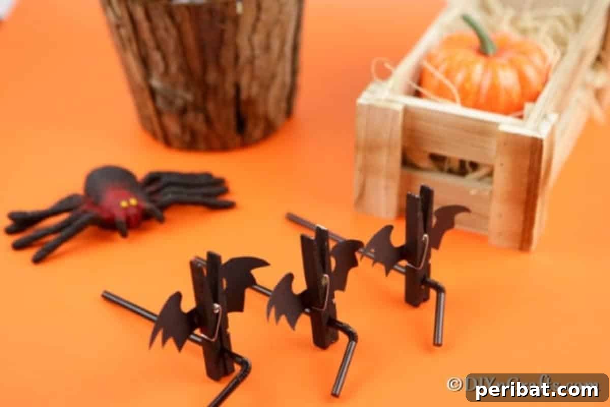 Spooky Fun Clothespin Bats for Halloween 3 Close-up of Halloween bat clothespins clipped onto drinking straws on an orange surface