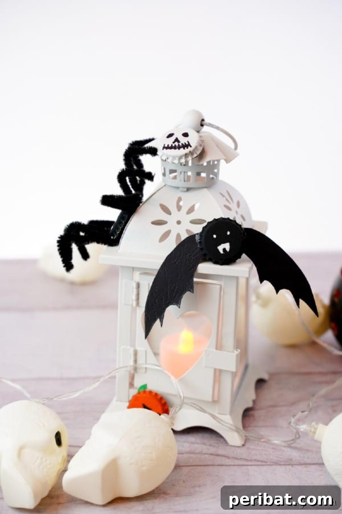 Bat and spider fun magnets made from bottle caps on a white lantern with white background