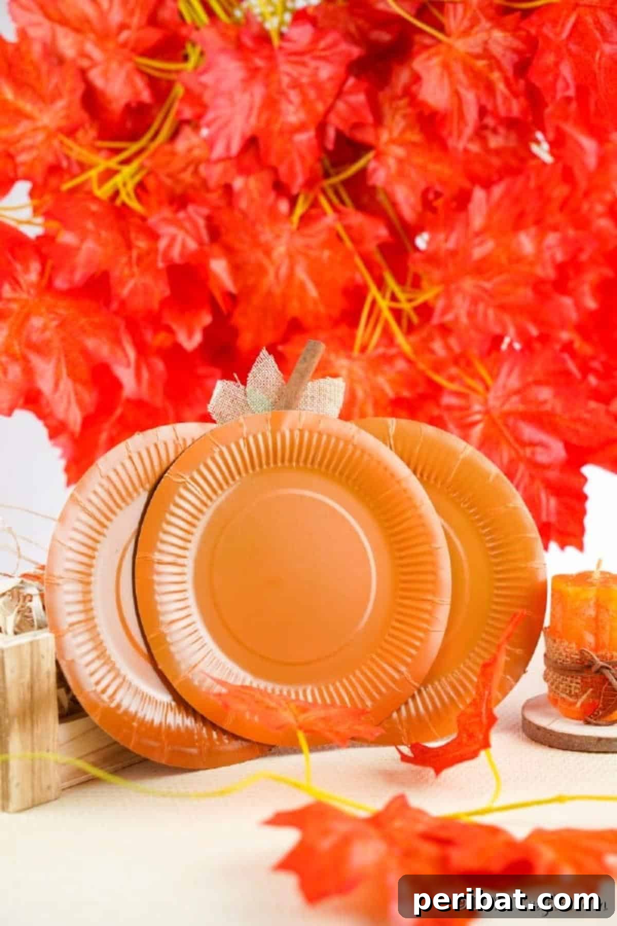 Fall Paper Plate Pumpkin Fun 4 A beautifully crafted paper pumpkin decoration, artfully positioned against a vibrant backdrop of faux fall leaves, highlighting its autumnal aesthetic.