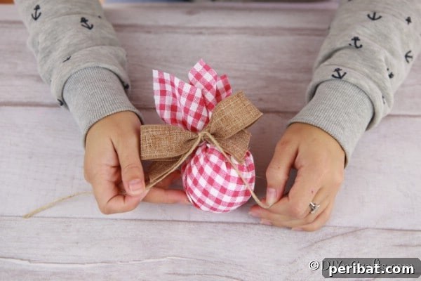 Cozy Plaid Tree Adornments 11 Tying a burlap bowl onto a checkered fabric Christmas tree ornament