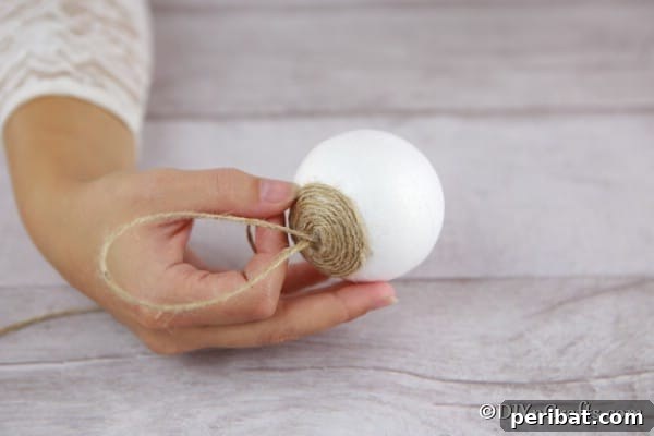 Beginning to glue twine in place on a styrofoam ball