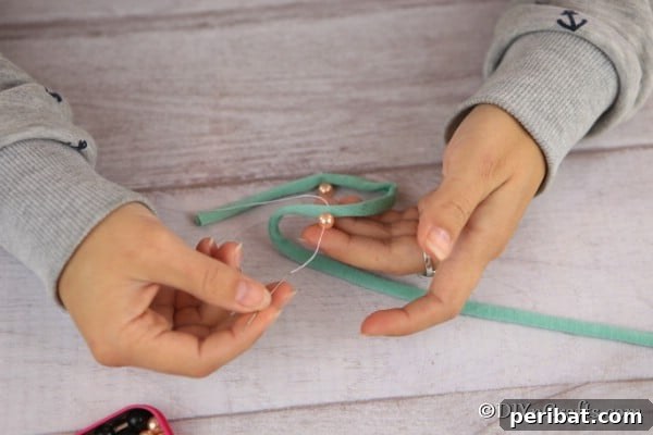 Adding pearls between branches of yarn for this handmade Christmas ornaments idea