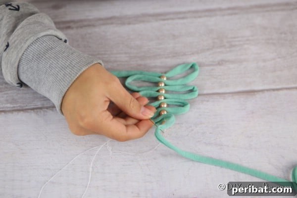 Threading pearls and ribbon to create a handmade Christmas ornaments tree