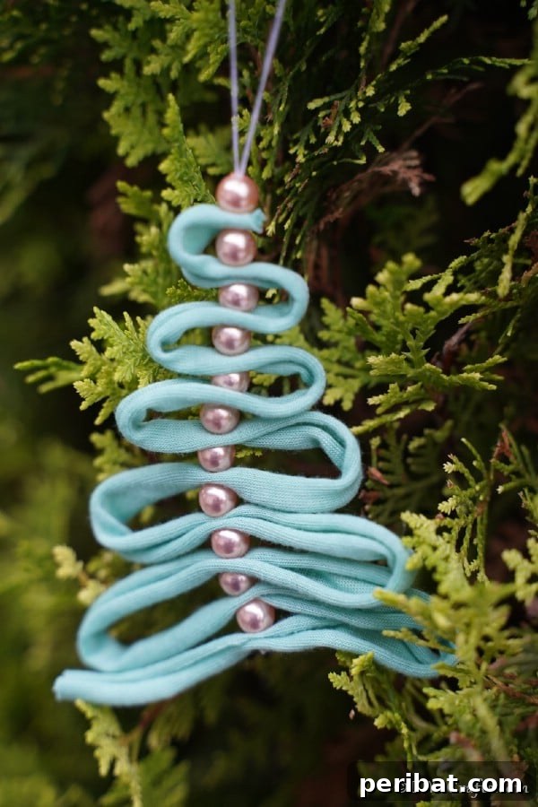 Up close picture of a ribbon ornament with pearl on a tree