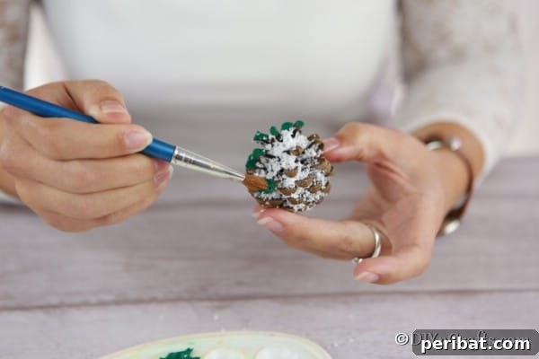 Tiny Pinecone Christmas Ornament 17 Painting the pieces of a pine cone ornament green, focusing on the tips