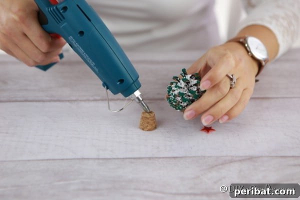Tiny Pinecone Christmas Ornament 18 Gluing the pine cone ornament on top of a wine bottle cork base for stability