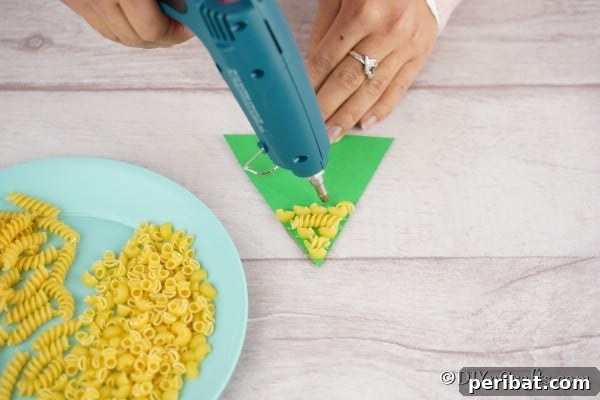 Whimsical Pasta Christmas Tree Decor 11 Gluing pasta to the cardboard Christmas decoration craft