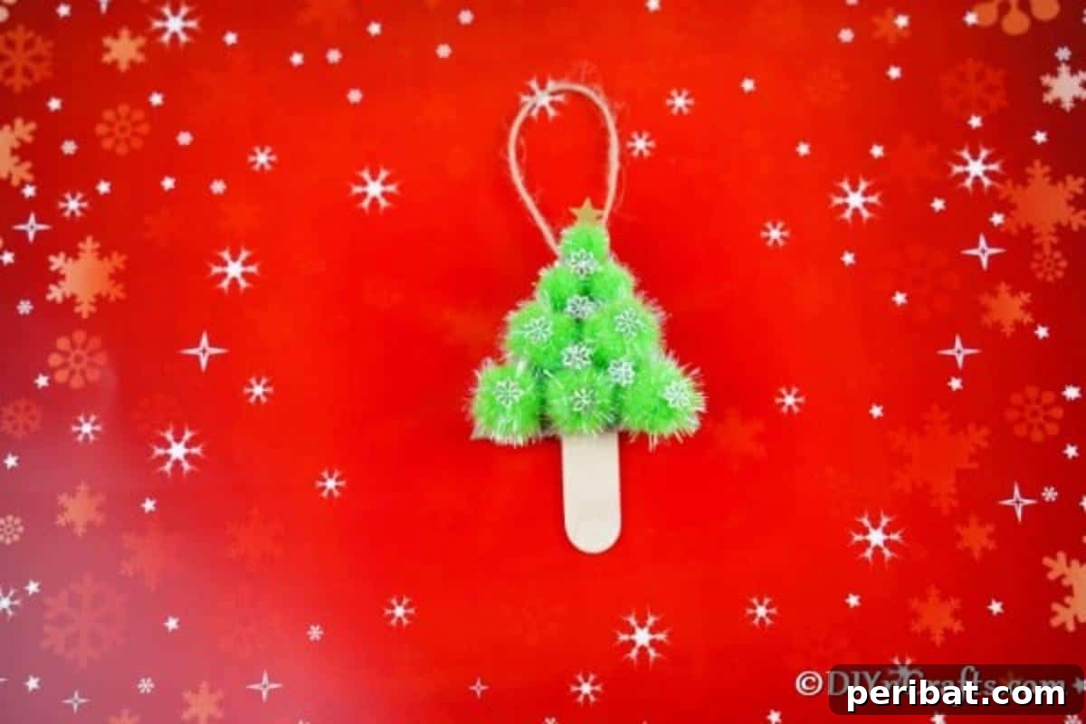Whimsical Pom Pom Christmas Tree Decoration 3 A beautifully decorated pom pom tree Christmas ornament resting on a vibrant red background