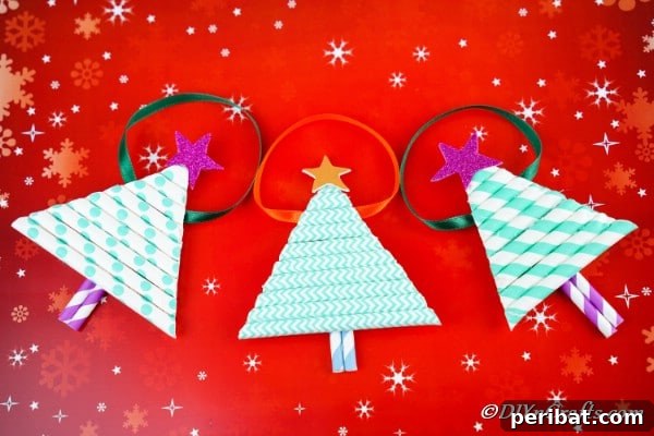 Paper Christmas tree craft ornaments laying on a red surface with holiday theme
