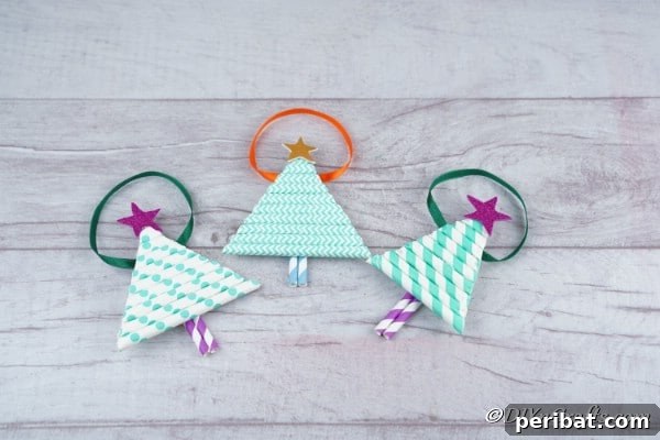 Three paper Christmas tree crafts on a wooden surface