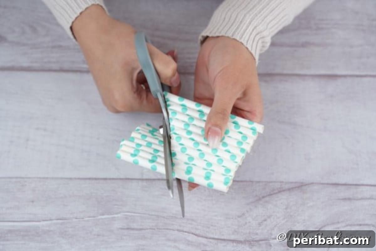 Cutting excess straws off the sides of the Christmas paper tree to form a triangular tree shape