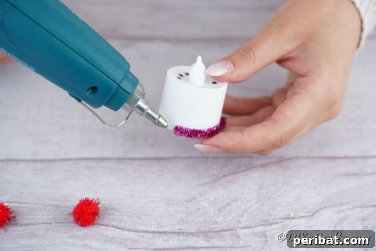 Affixing purple ribbon to the base of the Santa candle, creating a festive border